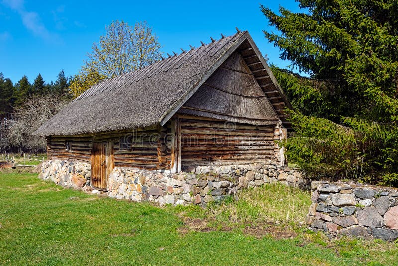 Old log barn with a thatched roof. Hiiumaa open-air museum Mihkli farm, Estonia. Most of the buildings date to the middle of the 18th century. One of the best preserved farmsteads. Old log barn with a thatched roof. Hiiumaa open-air museum Mihkli farm, Estonia. Most of the buildings date to the middle of the 18th century. One of the best preserved farmsteads.