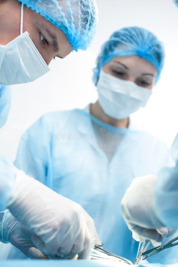Η πεπειραμένη χειρουργική ομάδα κάνει την εργασία τους στοκ φωτογραφία Η πεπειραμένη χειρουργική ομάδα κάνει την εργασία τους στοκ φωτογραφία
