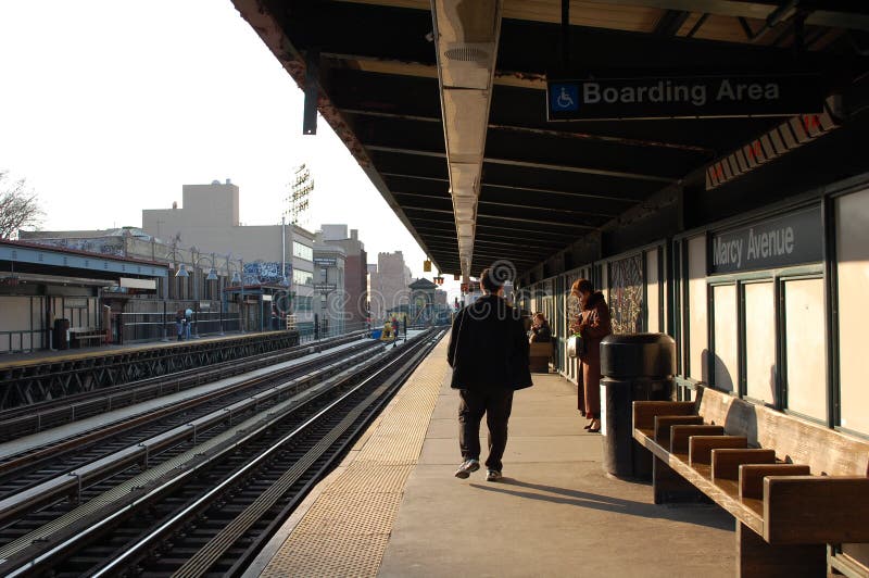 Sun begins to set on passengers waiting for a train to Manhattan at Marcy Avenue Station in Brooklyn. New York City. Sun begins to set on passengers waiting for a train to Manhattan at Marcy Avenue Station in Brooklyn. New York City.