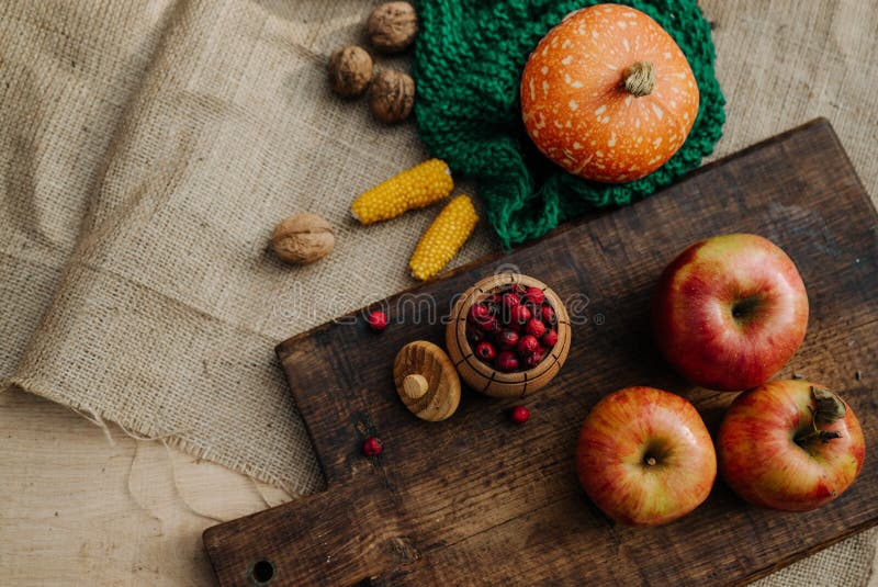 autumn harvest, orange pumpkin, nuts, corn, red berries and apples lie on the tablecloth 1. autumn harvest, orange pumpkin, nuts, corn, red berries and apples lie on the tablecloth 1