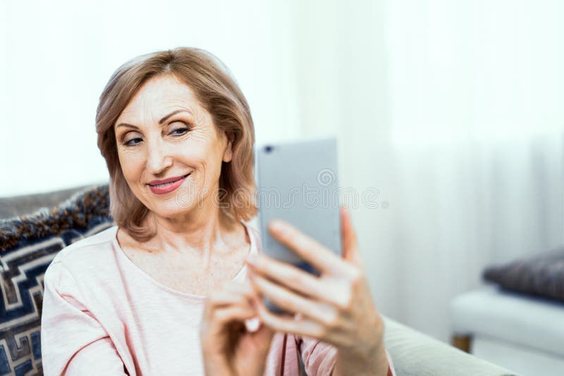 Η όμορφη ώριμη γυναίκα παίρνει selfie στο σπίτι στοκ φωτογραφία Η όμορφη ώριμη γυναίκα παίρνει selfie στο σπίτι στοκ φωτογραφία
