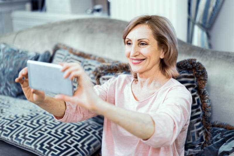 Η όμορφη ώριμη γυναίκα παίρνει selfie στο σπίτι στοκ φωτογραφίες Η όμορφη ώριμη γυναίκα παίρνει selfie στο σπίτι στοκ φωτογραφίες
