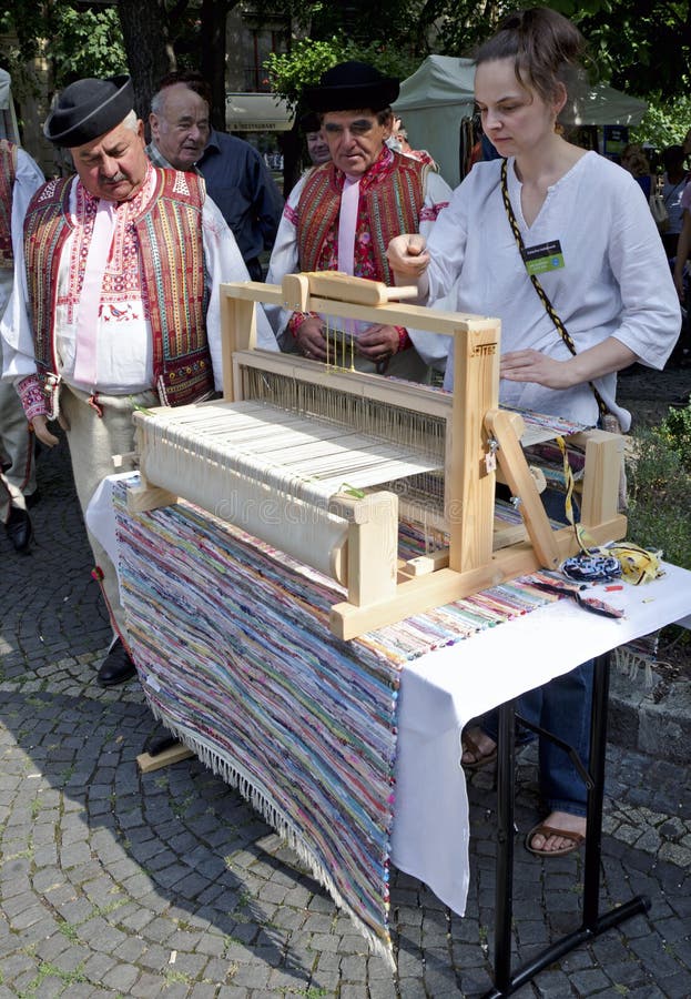 The young woman is waving the simple carpet during Festival Craftsmen Days ULUV in summer 2013 in Bratislava, Slovakia. Festival as a part of The Summer of Culture festival Bratislava, Slovakia, was held from August 31 to September 1, 2013, in the pedestrian zone of the Capital. There are over 100 craftsmen expected to attend and perform their skills in crafts. The young woman is waving the simple carpet during Festival Craftsmen Days ULUV in summer 2013 in Bratislava, Slovakia. Festival as a part of The Summer of Culture festival Bratislava, Slovakia, was held from August 31 to September 1, 2013, in the pedestrian zone of the Capital. There are over 100 craftsmen expected to attend and perform their skills in crafts.