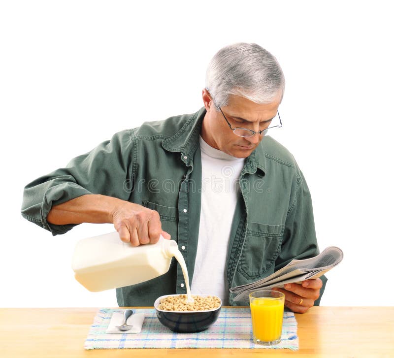 Casually dressed middle aged man pouring milk into his breakfast cereal bowl while reading the morning newspaper. Square format isolated over white. Casually dressed middle aged man pouring milk into his breakfast cereal bowl while reading the morning newspaper. Square format isolated over white.