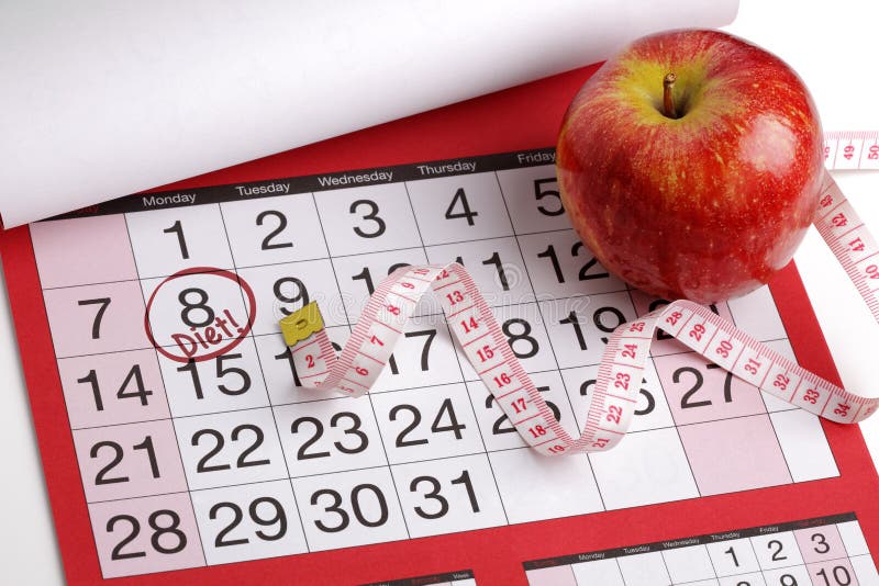 Dieting concept apple and tape measure on a calendar with a date to start a diet. Dieting concept apple and tape measure on a calendar with a date to start a diet