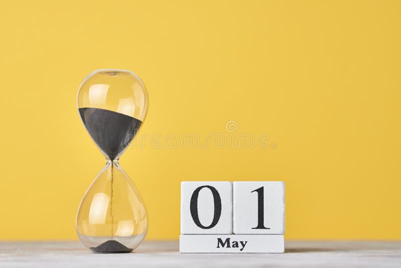 Date 1 may and hourglass on yellow background. Date 1 may and hourglass on yellow background