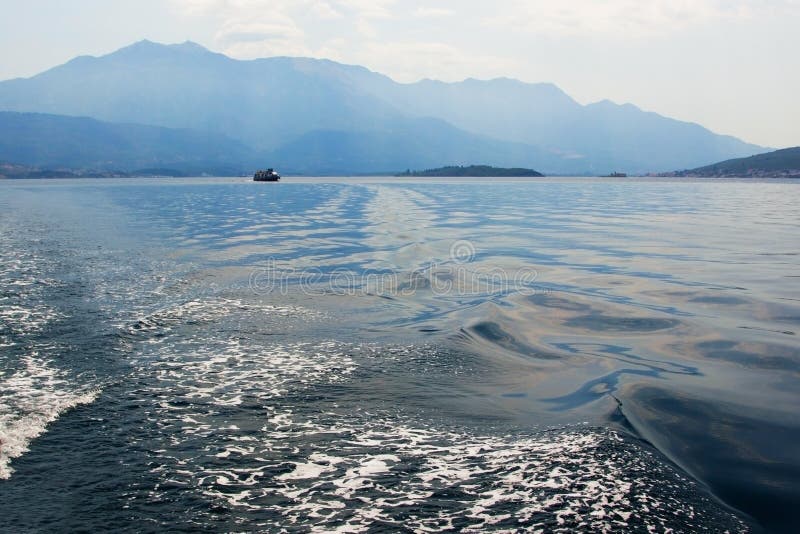 Θάλασσα και βουνά στο φως της βραδιάς Ένα μοναχικό πλοίο στον ορίζοντα στοκ φωτογραφίες με δικαίωμα ελεύθερης χρήσης Θάλασσα και βουνά στο φως της βραδιάς Ένα μοναχικό πλοίο στον ορίζοντα στοκ φωτογραφίες με δικαίωμα ελεύθερης χρήσης