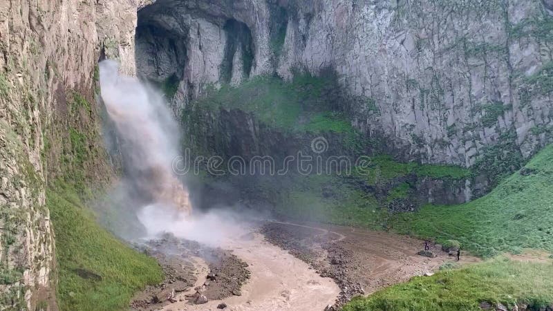 θέα ισχυρού καταρράκτη στα βουνά. καταρρέει το νερό και κάνει το ποτάμι με ισχυρή ροή.