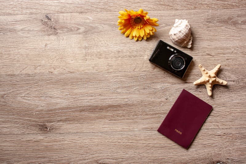 Θέμα του /travel διακοπών Flatlay με το καφετί υπόβαθρο με τη κάμερα, το διαβατήριο, το κοχύλι, τον αστερία και τα λουλούδια στοκ φωτογραφία με δικαίωμα ελεύθερης χρήσης