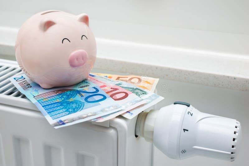 Θέρμανση της θερμοστάτη με τη piggy τράπεζα και τα χρήματα στοκ φωτογραφίες