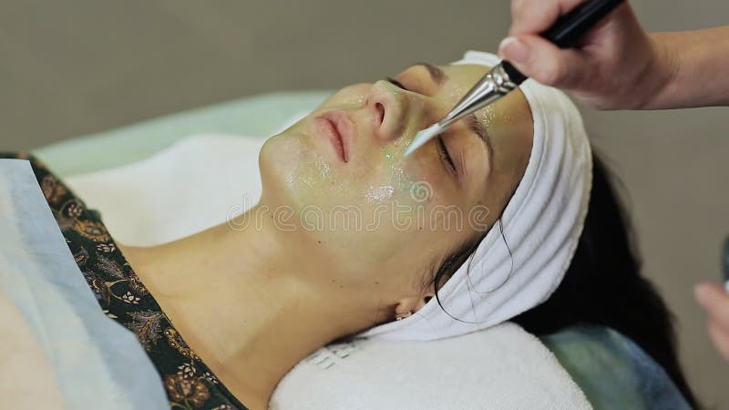 Θεραπεία SPA για τη νέα γυναίκα που έχει την καλλυντική μάσκα στο σαλόνι ομορφιάς Εφαρμογή μιας μάσκας σοκολάτας στο πρόσωπο κορι απόθεμα βίντεο Θεραπεία SPA για τη νέα γυναίκα που έχει την καλλυντική μάσκα στο σαλόνι ομορφιάς Εφαρμογή μιας μάσκας σοκολάτας στο πρόσωπο κορι απόθεμα βίντεο