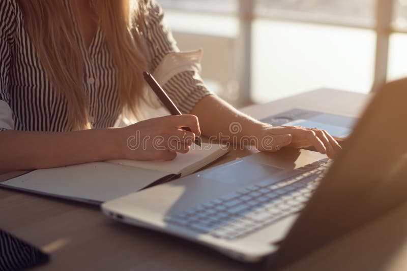 Θηλυκά χέρια γυναικών freelancer με τη μάνδρα που γράφει στο σημειωματάριο στο σπίτι ή το γραφείο στοκ εικόνα με δικαίωμα ελεύθερης χρήσης