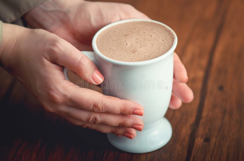 Θηλυκά χέρια που κρατούν tenderly το φλυτζάνι του κακάου στοκ φωτογραφία με δικαίωμα ελεύθερης χρήσης