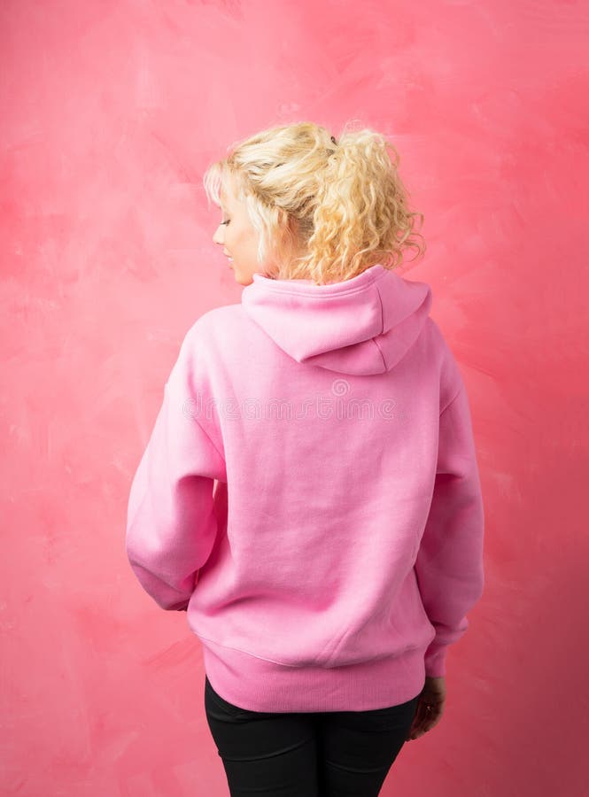 Θηλυκό στο ρόδινο hoodie που στέκεται με την που γυρίζουν πίσω στοκ εικόνες Θηλυκό στο ρόδινο hoodie που στέκεται με την που γυρίζουν πίσω στοκ εικόνες