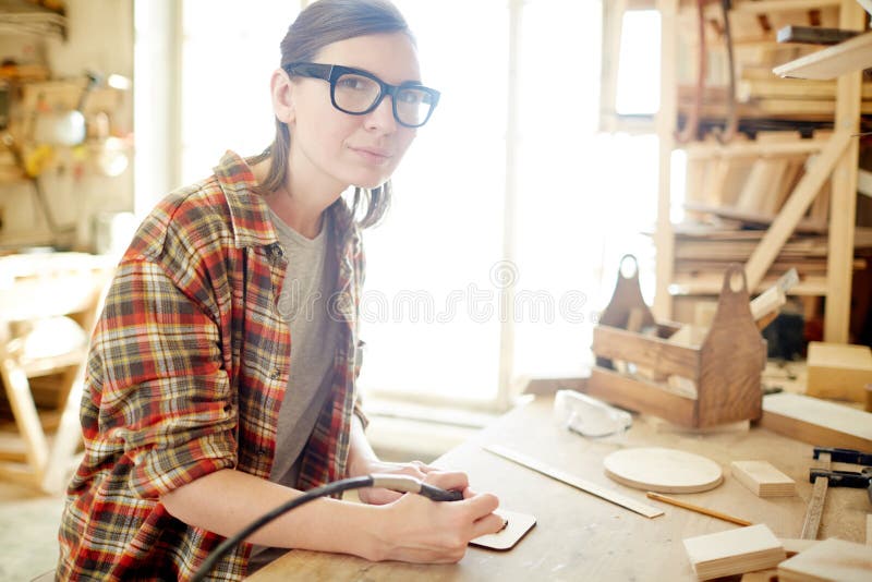 Θηλυκός ξυλουργός που χρησιμοποιεί pyrography τον καυστήρα στοκ εικόνες με δικαίωμα ελεύθερης χρήσης Θηλυκός ξυλουργός που χρησιμοποιεί pyrography τον καυστήρα στοκ εικόνες με δικαίωμα ελεύθερης χρήσης