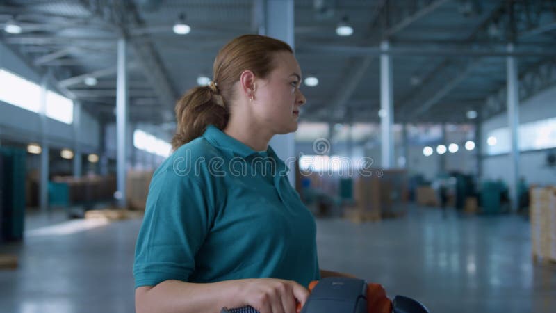 θηλυκός φορέας εκμετάλλευσης οχήματος του αποθηκευτικού οίκου που μεταφέρει παλέτες εργασίας φορτίων φιλμ μικρού μήκους