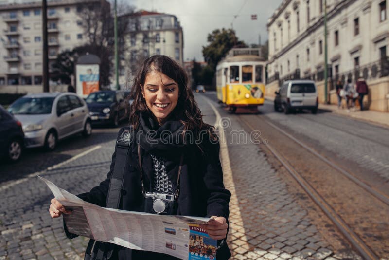 Θηλυκός χάρτης ταξιδιωτικής εκμετάλλευσης και τουριστών ανάγνωσης στοκ εικόνες Θηλυκός χάρτης ταξιδιωτικής εκμετάλλευσης και τουριστών ανάγνωσης στοκ εικόνες