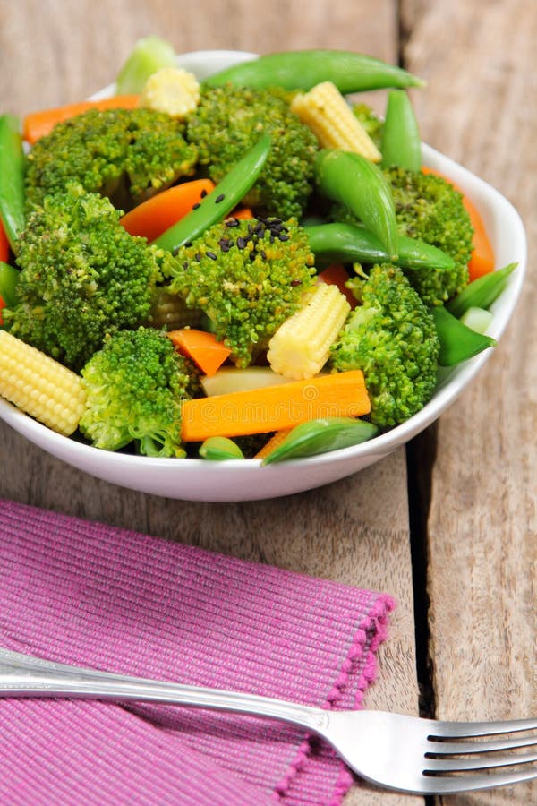 Broccoli salad with carrot ,baby corn and snap pea in a white bowl. Broccoli salad with carrot ,baby corn and snap pea in a white bowl