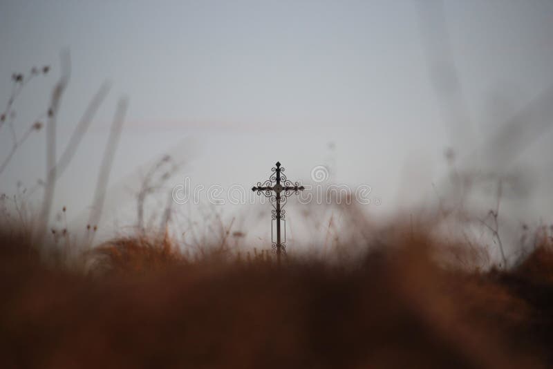 Θρησκευτικό υπόβαθρο με τη θολωμένη καφετιά χλόη φθινοπώρου και έναν σταυρό περαιτέρω επάνω στοκ εικόνες Θρησκευτικό υπόβαθρο με τη θολωμένη καφετιά χλόη φθινοπώρου και έναν σταυρό περαιτέρω επάνω στοκ εικόνες