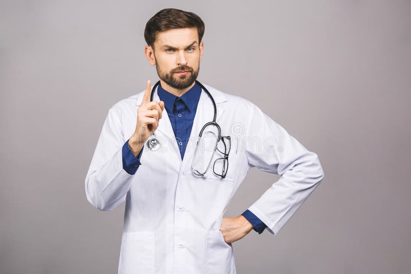 Angry male doctor pointing finger at you with stethoscope around his neck, pointing at camera with serious face isolated on grey background. Angry male doctor pointing finger at you with stethoscope around his neck, pointing at camera with serious face isolated on grey background