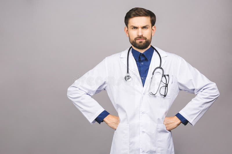 Angry serious male doctor looking at you with stethoscope around his neck, serious face isolated on grey background. Angry serious male doctor looking at you with stethoscope around his neck, serious face isolated on grey background