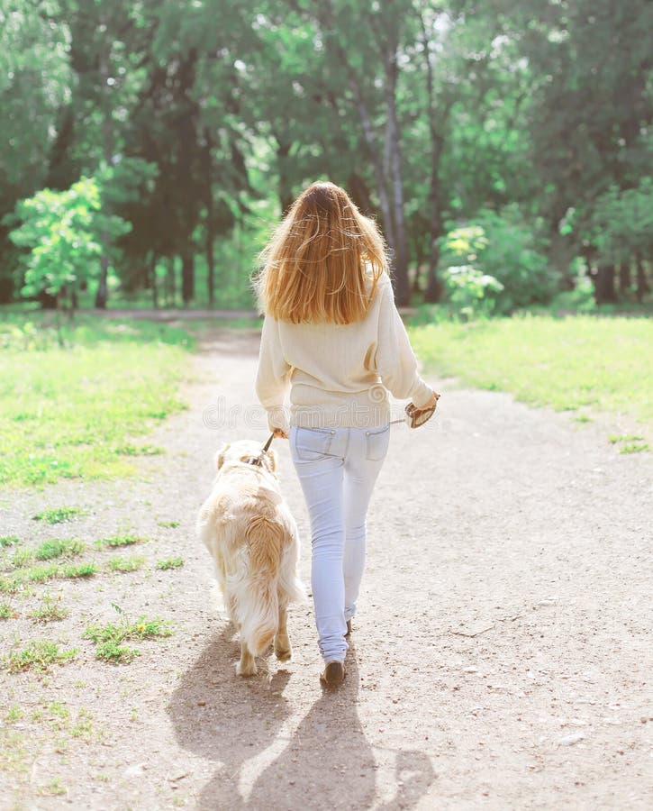 Ιδιοκτήτης και ευτυχές χρυσό Retriever σκυλί που περπατούν το καλοκαίρι στοκ φωτογραφίες με δικαίωμα ελεύθερης χρήσης Ιδιοκτήτης και ευτυχές χρυσό Retriever σκυλί που περπατούν το καλοκαίρι στοκ φωτογραφίες με δικαίωμα ελεύθερης χρήσης