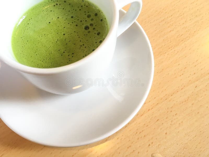 Ιαπωνικό πράσινο τσάι matcha latte σε ένα άσπρο φλυτζάνι και ένα άσπρο πιατάκι στοκ φωτογραφία με δικαίωμα ελεύθερης χρήσης Ιαπωνικό πράσινο τσάι matcha latte σε ένα άσπρο φλυτζάνι και ένα άσπρο πιατάκι στοκ φωτογραφία με δικαίωμα ελεύθερης χρήσης