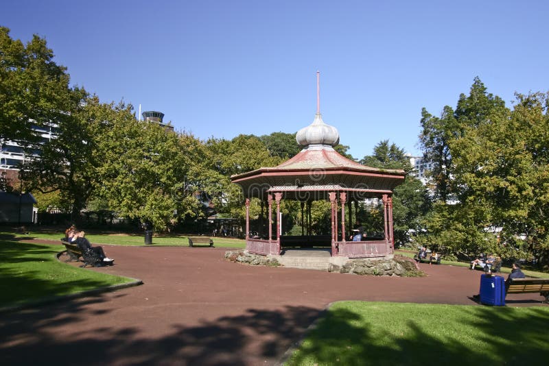 Ιστορικό βικτοριανό ξύλινο gazebo με κρεμμύδι-διαμορφωμένη τη μέταλλο στέγη, και χλόη και δέντρα σε Αλβέρτο Park, Ώκλαντ CBD, Νέα στοκ φωτογραφία με δικαίωμα ελεύθερης χρήσης Ιστορικό βικτοριανό ξύλινο gazebo με κρεμμύδι-διαμορφωμένη τη μέταλλο στέγη, και χλόη και δέντρα σε Αλβέρτο Park, Ώκλαντ CBD, Νέα στοκ φωτογραφία με δικαίωμα ελεύθερης χρήσης