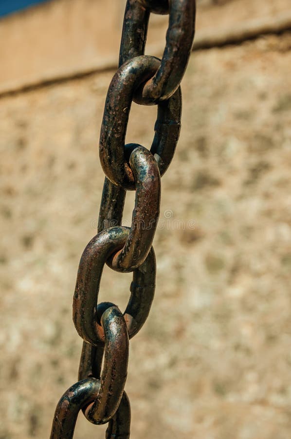 Ισχυρές συνδέσεις αλυσίδων σιδήρου μπροστά από τον τοίχο πετρών στοκ φωτογραφία με δικαίωμα ελεύθερης χρήσης Ισχυρές συνδέσεις αλυσίδων σιδήρου μπροστά από τον τοίχο πετρών στοκ φωτογραφία με δικαίωμα ελεύθερης χρήσης
