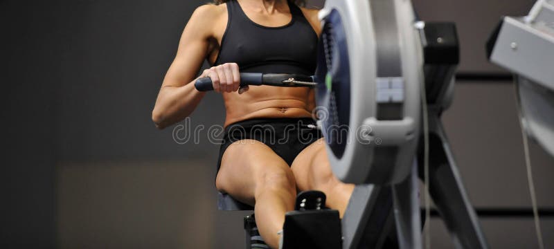 Ισχυρή ελκυστική μυϊκή γυναίκα CrossFit trainer do workout στο εσωτερικό rower στη γυμναστική στοκ φωτογραφία με δικαίωμα ελεύθερης χρήσης Ισχυρή ελκυστική μυϊκή γυναίκα CrossFit trainer do workout στο εσωτερικό rower στη γυμναστική στοκ φωτογραφία με δικαίωμα ελεύθερης χρήσης