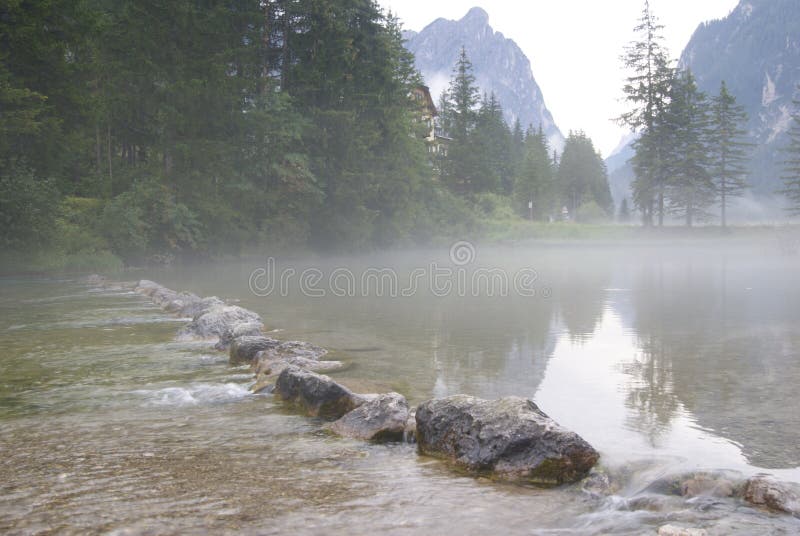 Ιταλική λίμνη της Misty που διατρέχει των βράχων στοκ εικόνα Ιταλική λίμνη της Misty που διατρέχει των βράχων στοκ εικόνα