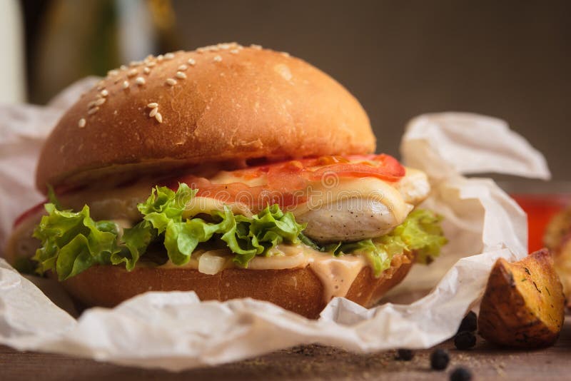 Κλασικό burger με τις σφήνες κοτόπουλου και πατατών στοκ φωτογραφία