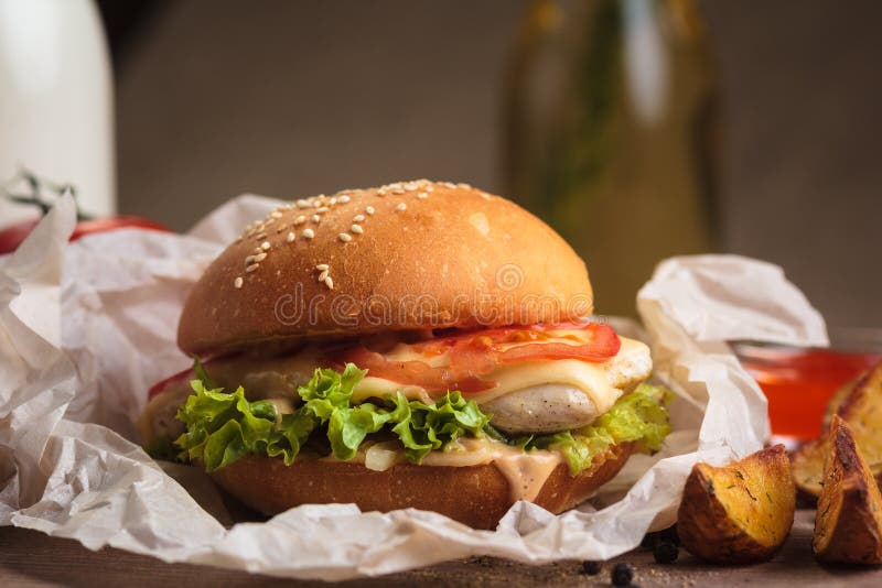 Κλασικό burger με τις σφήνες κοτόπουλου και πατατών στοκ φωτογραφία με δικαίωμα ελεύθερης χρήσης