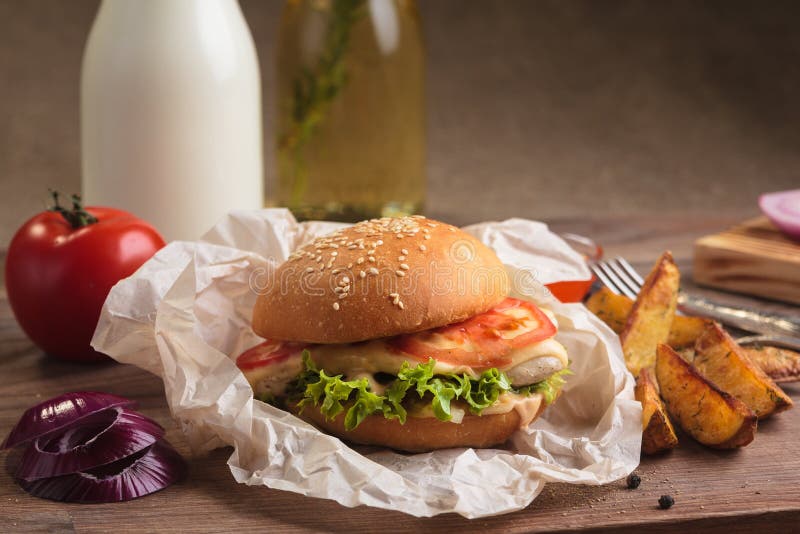 Κλασικό burger με τις σφήνες κοτόπουλου και πατατών στοκ φωτογραφία με δικαίωμα ελεύθερης χρήσης