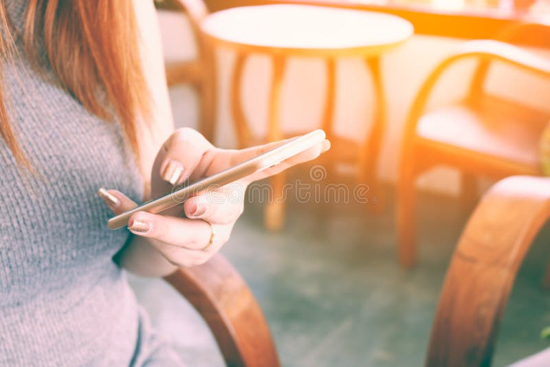 Κλείστε επάνω το μήνυμα δακτυλογράφησης χεριών γυναικών στο έξυπνο τηλέφωνο σε έναν καφέ στοκ φωτογραφία Κλείστε επάνω το μήνυμα δακτυλογράφησης χεριών γυναικών στο έξυπνο τηλέφωνο σε έναν καφέ στοκ φωτογραφία