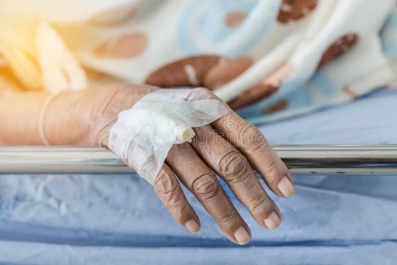 Κλείστε επάνω το χέρι του ηλικιωμένου ασθενή με τον ενδοφλέβιο καθετήρα για το βούλωμα εγχύσεων υπό εξέταση στοκ εικόνες με δικαίωμα ελεύθερης χρήσης Κλείστε επάνω το χέρι του ηλικιωμένου ασθενή με τον ενδοφλέβιο καθετήρα για το βούλωμα εγχύσεων υπό εξέταση στοκ εικόνες με δικαίωμα ελεύθερης χρήσης