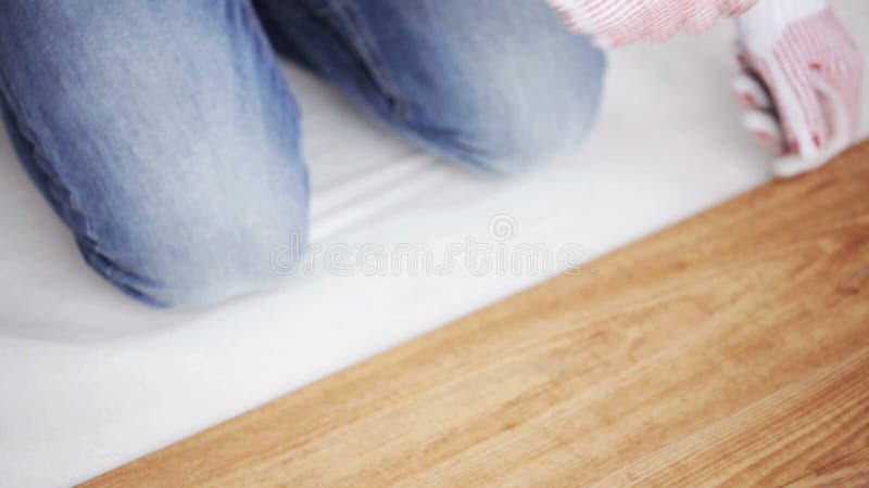 Κλείστε επάνω του ατόμου που εγκαθιστά το ξύλινο δάπεδο φιλμ μικρού μήκους
