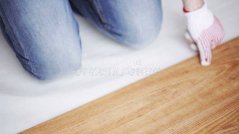 Κλείστε επάνω του ατόμου που εγκαθιστά το ξύλινο δάπεδο φιλμ μικρού μήκους
