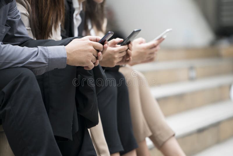 Κλείστε επάνω των επιχειρηματιών και των επιχειρηματιών χρησιμοποιώντας το smartphone στοκ φωτογραφίες