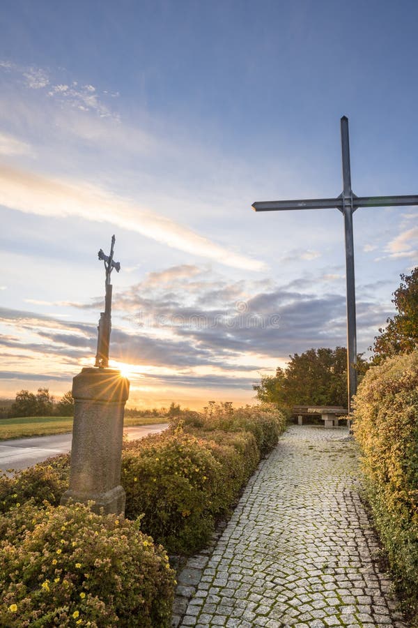 A vertical of a pathway lined with crosses at sunset. A vertical of a pathway lined with crosses at sunset