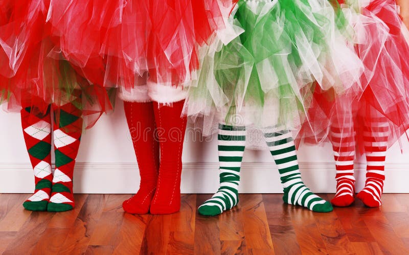 Four little girls wearing christmas socks and tutu's. Four little girls wearing christmas socks and tutu's