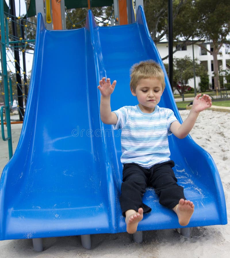 Close up of young boy sliding in the park. Close up of young boy sliding in the park