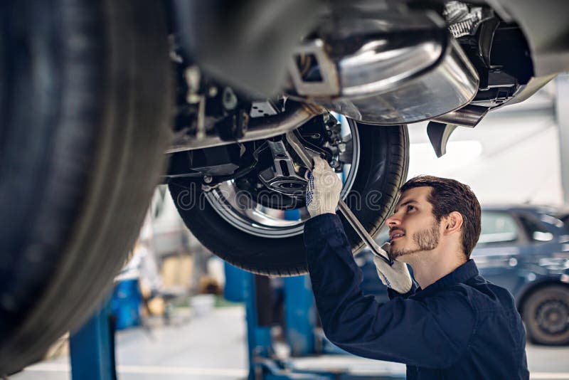 Auto car repair service center. Mechanic examining car suspension. Auto car repair service center. Mechanic examining car suspension.