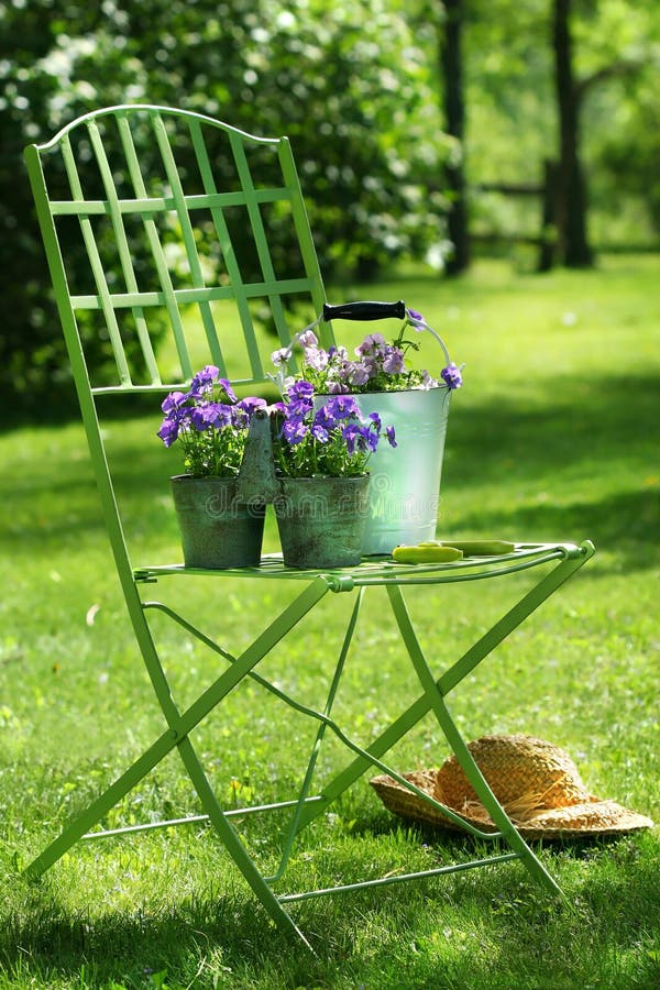 Green garden chair with straw hat. Green garden chair with straw hat