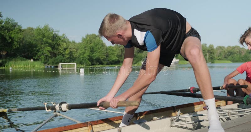 Κίεβο UA, 31-07-2019 Αθλητική ομάδα εφήβων με προπονητή να κατεβάζει καγιάκ με βάρκα στο νερό