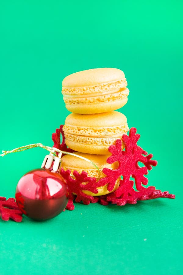 Κίτρινα macaroons με τις νέες διακοσμήσεις έτους στο πράσινο υπόβαθρο στοκ εικόνες Κίτρινα macaroons με τις νέες διακοσμήσεις έτους στο πράσινο υπόβαθρο στοκ εικόνες