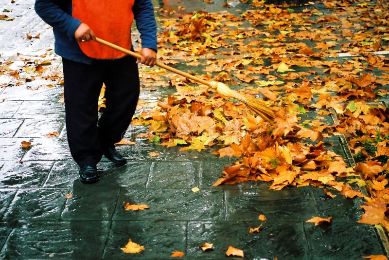 Autumn street cleaner. A city worker steam-cleans the sidewalk. Autumn street cleaner. A city worker steam-cleans the sidewalk.