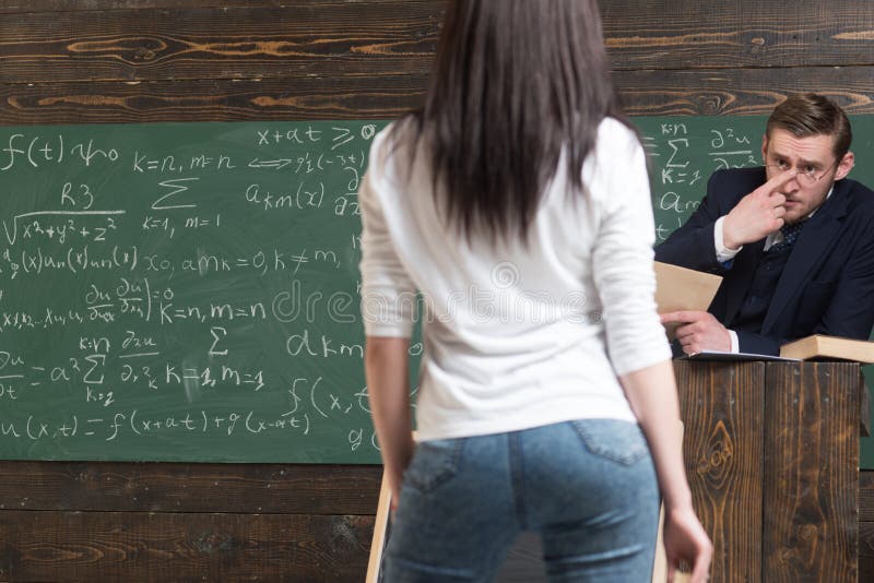 Καθηγητής Math που κοιτάζει επίμονα στη νέα όμορφη γυναίκα σπουδαστή του Πίσω κορίτσι στροφής με τη συμπαθητική άκρη που στέκεται στοκ εικόνα με δικαίωμα ελεύθερης χρήσης Καθηγητής Math που κοιτάζει επίμονα στη νέα όμορφη γυναίκα σπουδαστή του Πίσω κορίτσι στροφής με τη συμπαθητική άκρη που στέκεται στοκ εικόνα με δικαίωμα ελεύθερης χρήσης