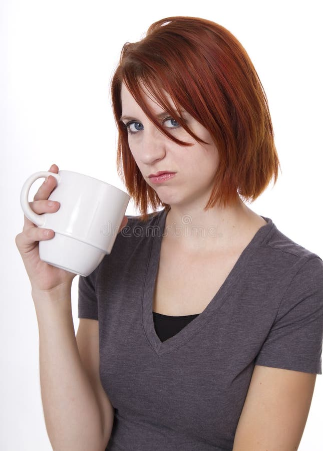 Redhead woman expresses her displeasure while having a cup of. Redhead woman expresses her displeasure while having a cup of