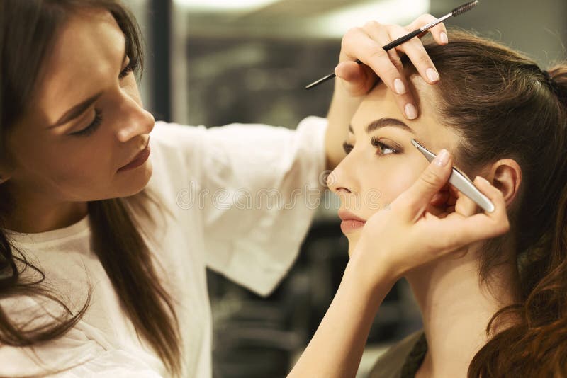 Καλλιτέχνης Brow που μαδά και που διαμορφώνει Brows του κοριτσιού στο στούντιο ομορφιάς στοκ εικόνα με δικαίωμα ελεύθερης χρήσης Καλλιτέχνης Brow που μαδά και που διαμορφώνει Brows του κοριτσιού στο στούντιο ομορφιάς στοκ εικόνα με δικαίωμα ελεύθερης χρήσης